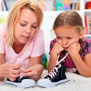 ребенок учится завязывать шнурки