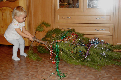 ребнок разбирает новогоднюю елку