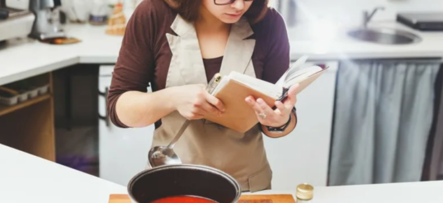 девушка готовит по кулинарной книге